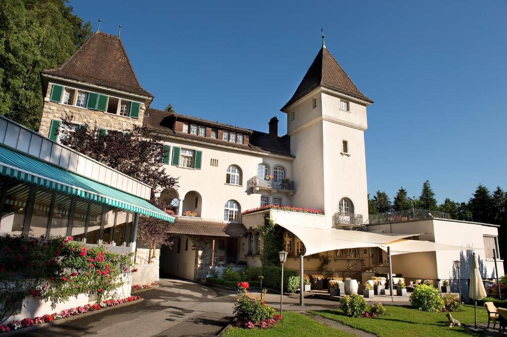 un grand bâtiment blanc avec une tour d'horloge dans l'établissement Hotel Schloss Ragaz, à Bad Ragaz