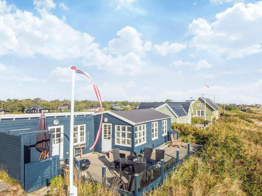 a row of houses on a beach with a table at 4 person holiday home in Grenaa in Grenå