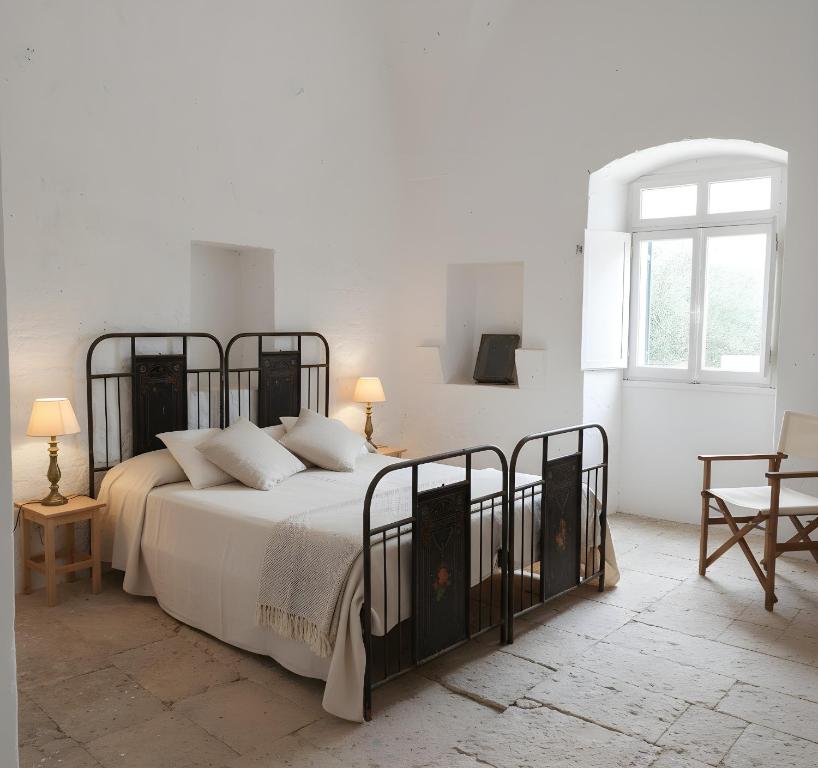 een witte slaapkamer met een groot bed met witte muren bij La Posta dell'Eremo in Ostuni
