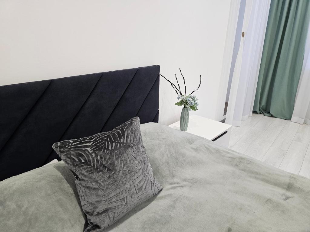 a bed with a black headboard and a pillow on it at Новинка ЖК Тріумф поряд вокзалу in Luts'k