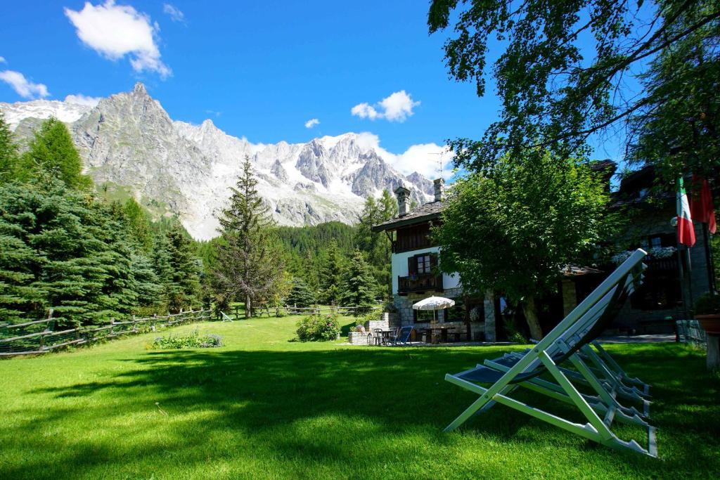 a yard with a house and a mountain at Hotel Locanda Belvedere in Courmayeur