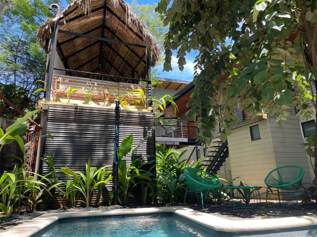 a swimming pool in front of a house at Mar Botánico - Avellanas Beach Hotel in Playa Avellana