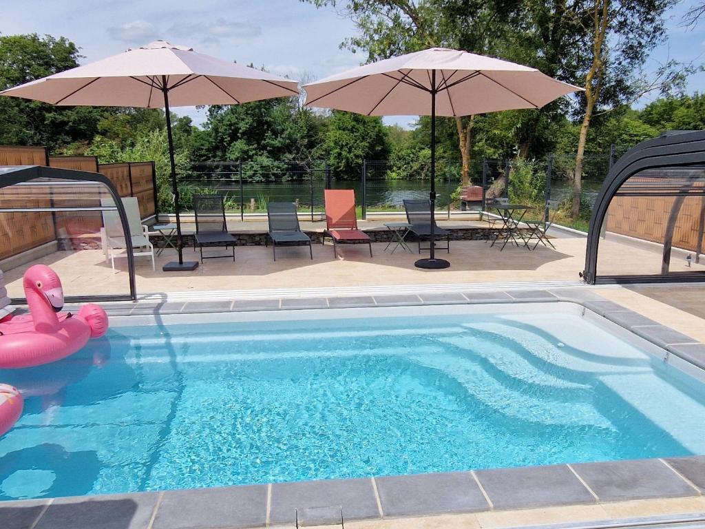 a swimming pool with two umbrellas and a table and chairs at Maison de charme en bord du Loir, 6-8 pers, proche Zoo de La Flèche, piscine à venir, parking inclus - FR-1-410-429 in La Flèche