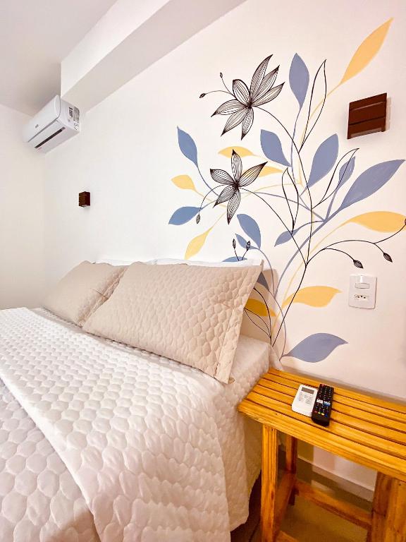 a bedroom with a bed with a flower mural on the wall at Pousada Solana in Salvador