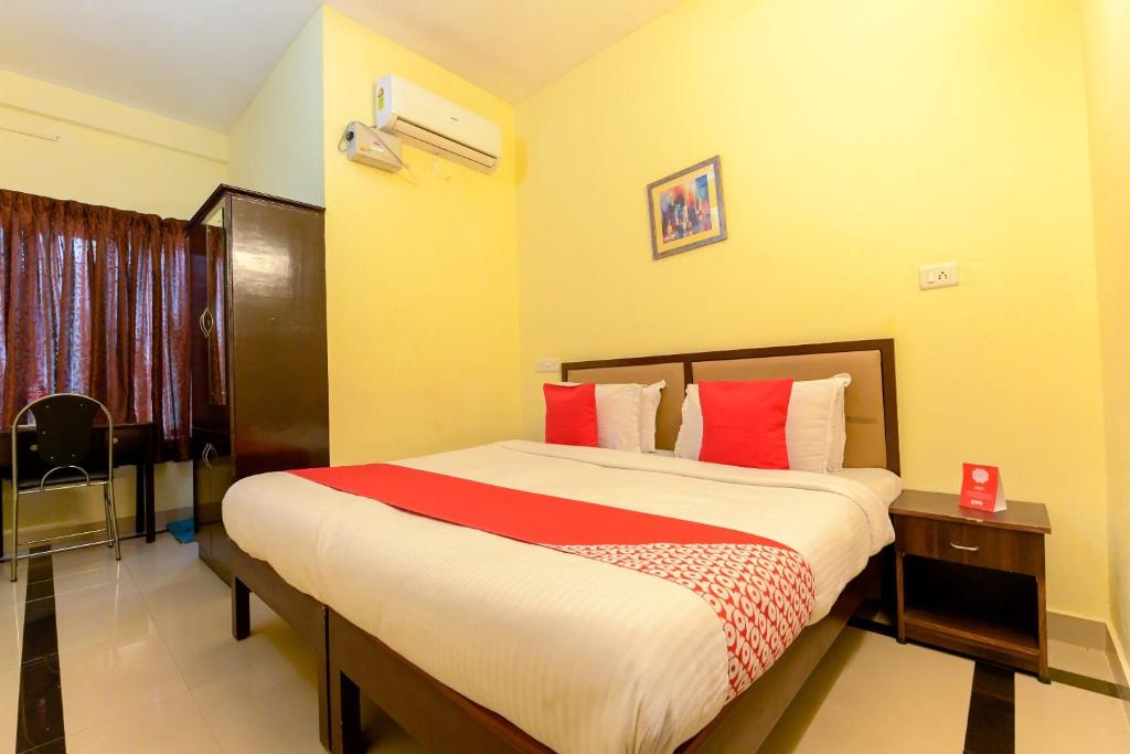 a bedroom with a large bed with red pillows at Super Hotel O Diamond In in Cochin