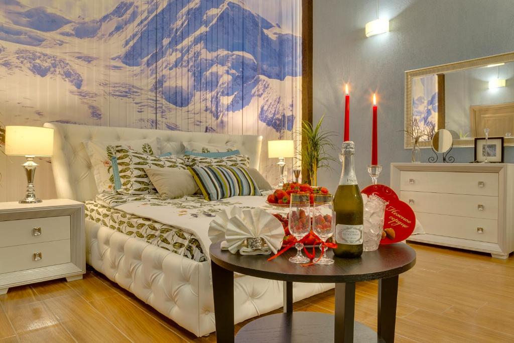 a bedroom with a bed with a table with wine glasses at Apartment City in Saint Petersburg