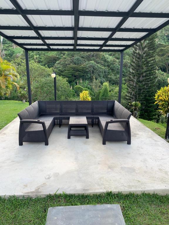 a patio with a couch and two tables under a pergola at La Miel in Barbosa