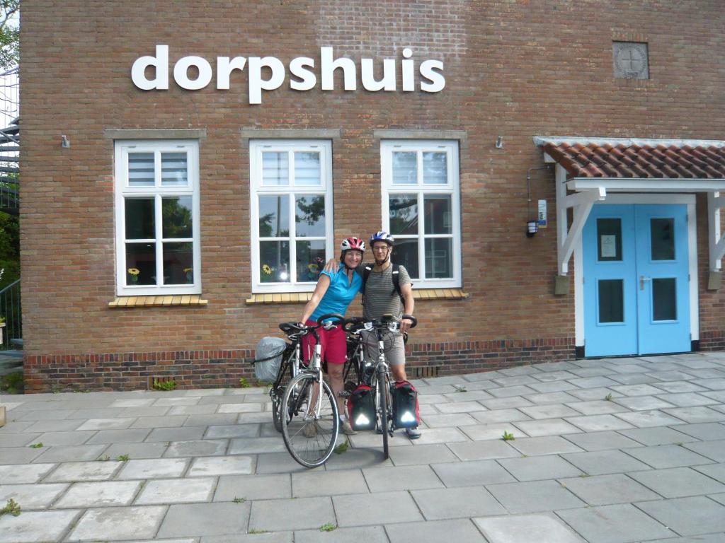 een man en een vrouw die naast hun fietsen staan bij Dorpslogement Pieterburen in Pieterburen