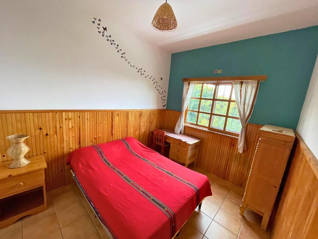 a bedroom with a red bed and a window at View of Atitlán Private apartment with balcony in Sololá