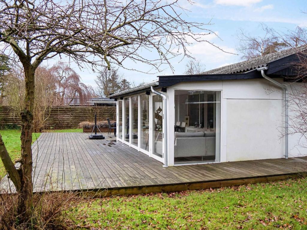 a small white shed with a wooden deck at 5 star holiday home in Vig in Glostrup