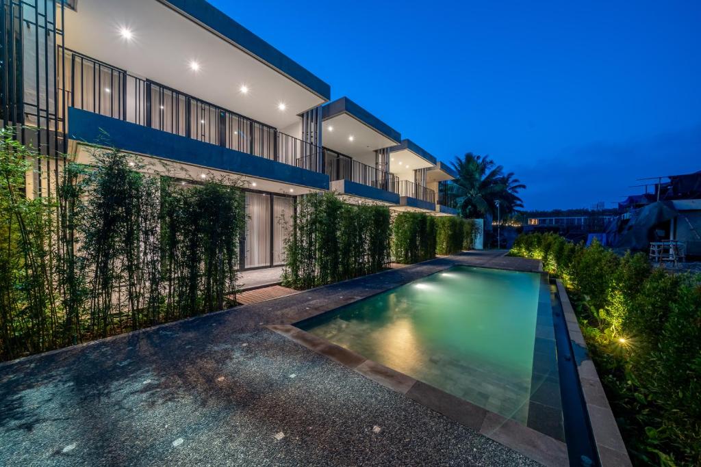 a swimming pool in front of a house at night at Townhouse T2 -Live Like a Local - Sophisticated Townhouse in Ubud in Ubud