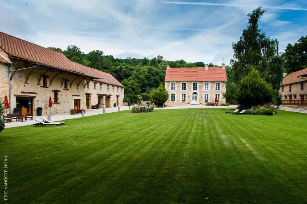 duży zielony trawnik przed budynkiem w obiekcie Domaine de la Pommeraye & Spa w mieście La Pommeraye