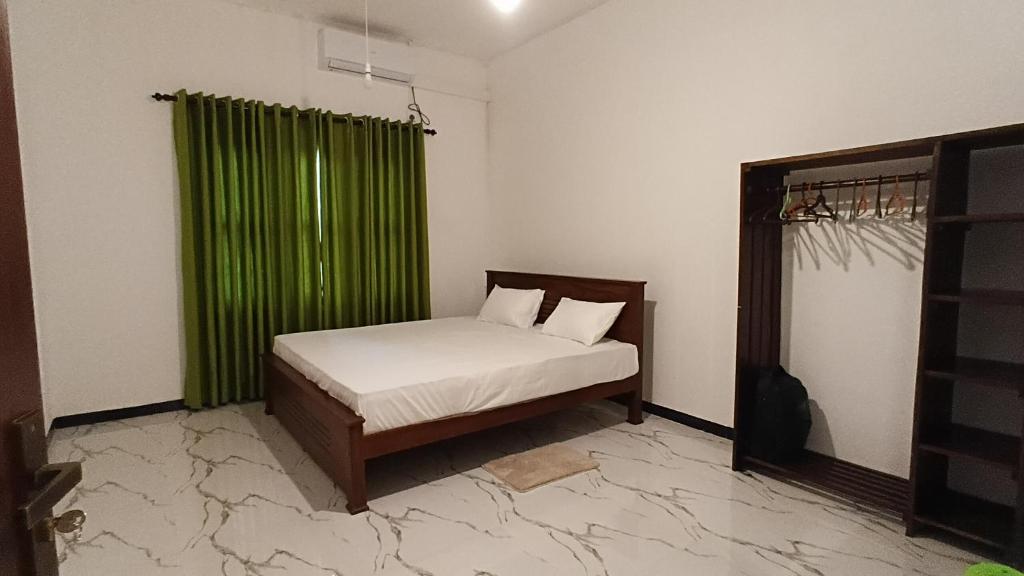 韦利格默Dilana Villa的卧室里有一张带绿色窗帘的床