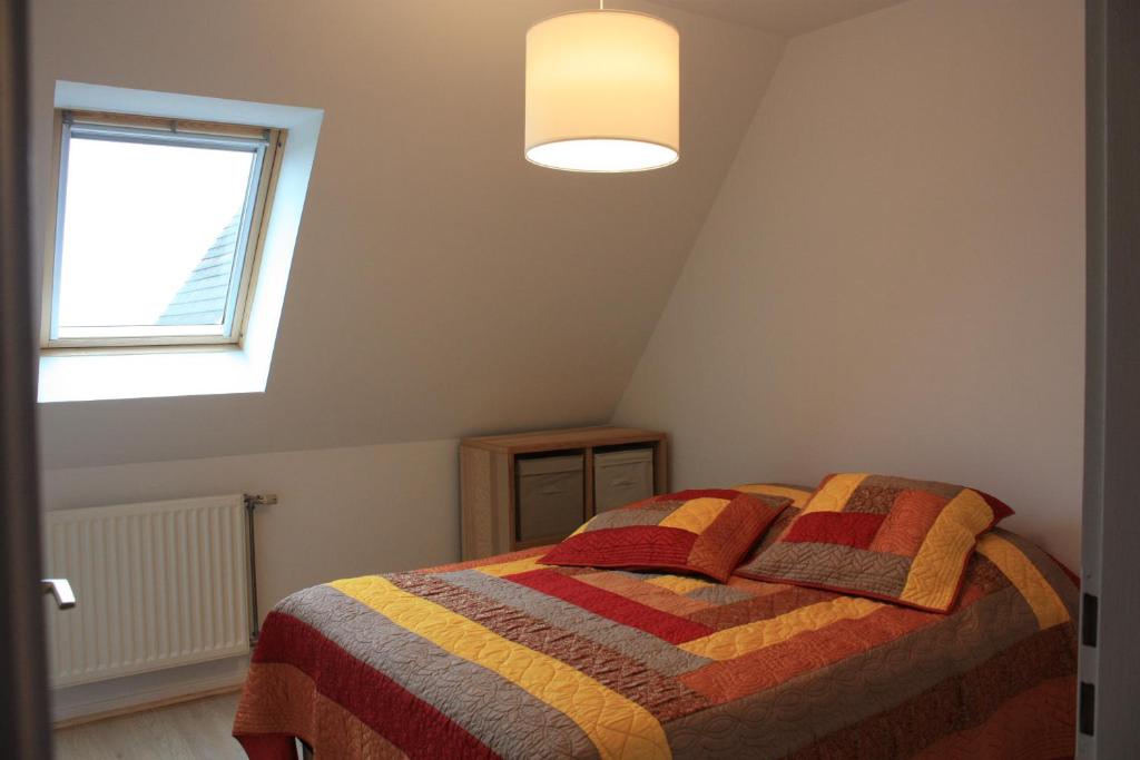 リボーヴィレにあるGite Le coeur des Ribeaupierresのベッドルーム1室(カラフルな毛布付きのベッド1台付)
