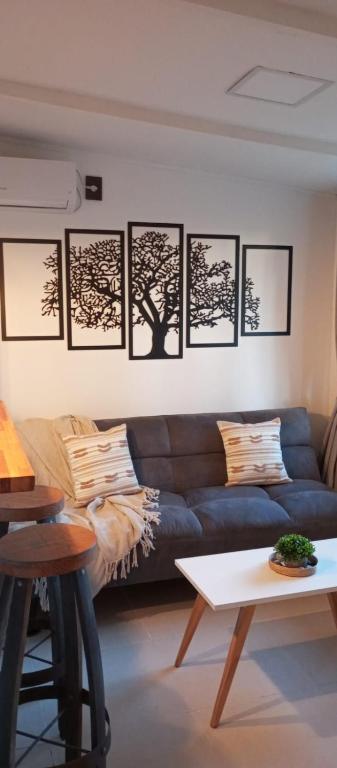 a living room with a blue couch and pictures on the wall at El refugio in La Paloma