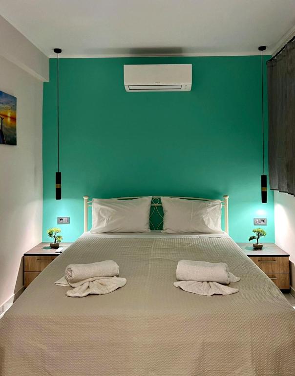 a bedroom with a large bed with a green wall at Margaret House in Zakynthos