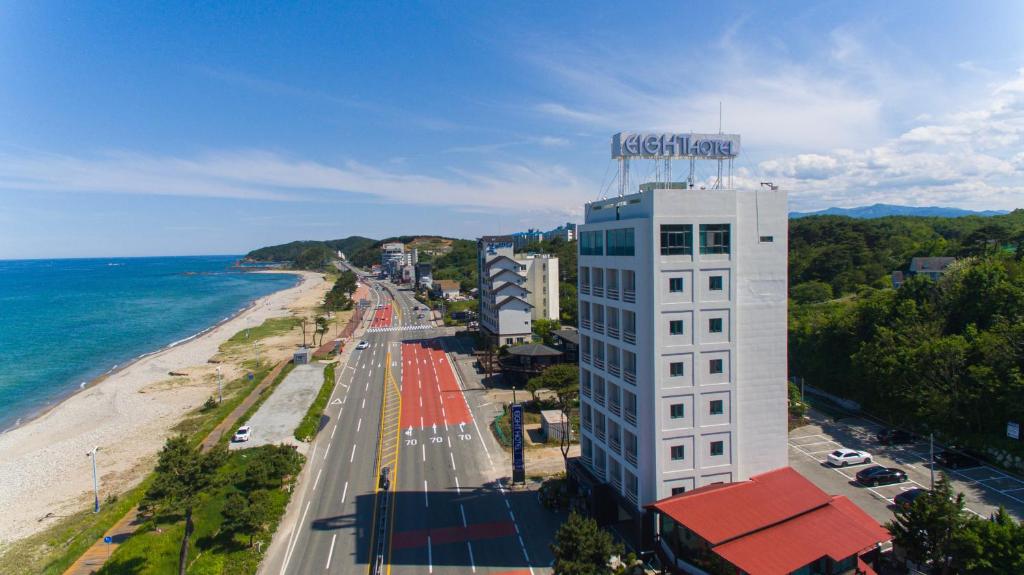 a building with a sign on top of it next to a beach at Yangyang Eight in Yongho-ri