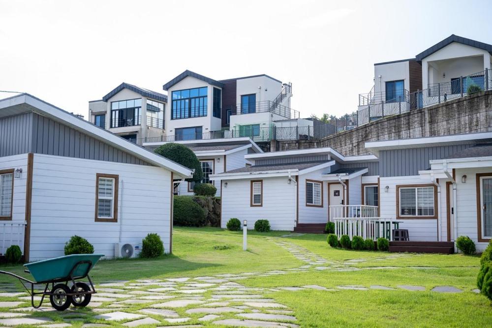 a green wheelbarrow in front of a row of houses at Yiriro Stay in Kwangnyŏng-ni