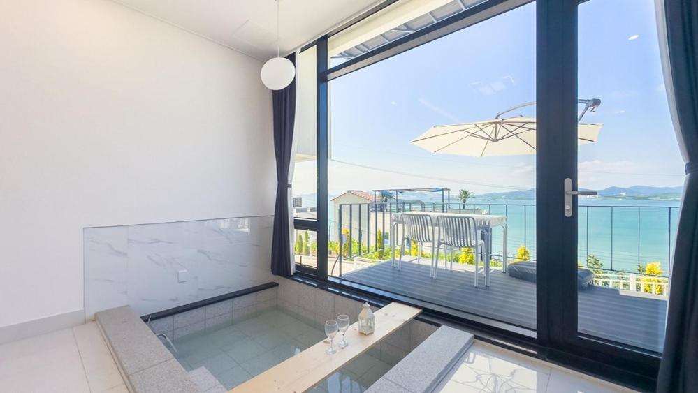 a swimming pool with a view of the ocean at Yeosu Road 328 Ocean View Pool Villa in P'yongsa-ri