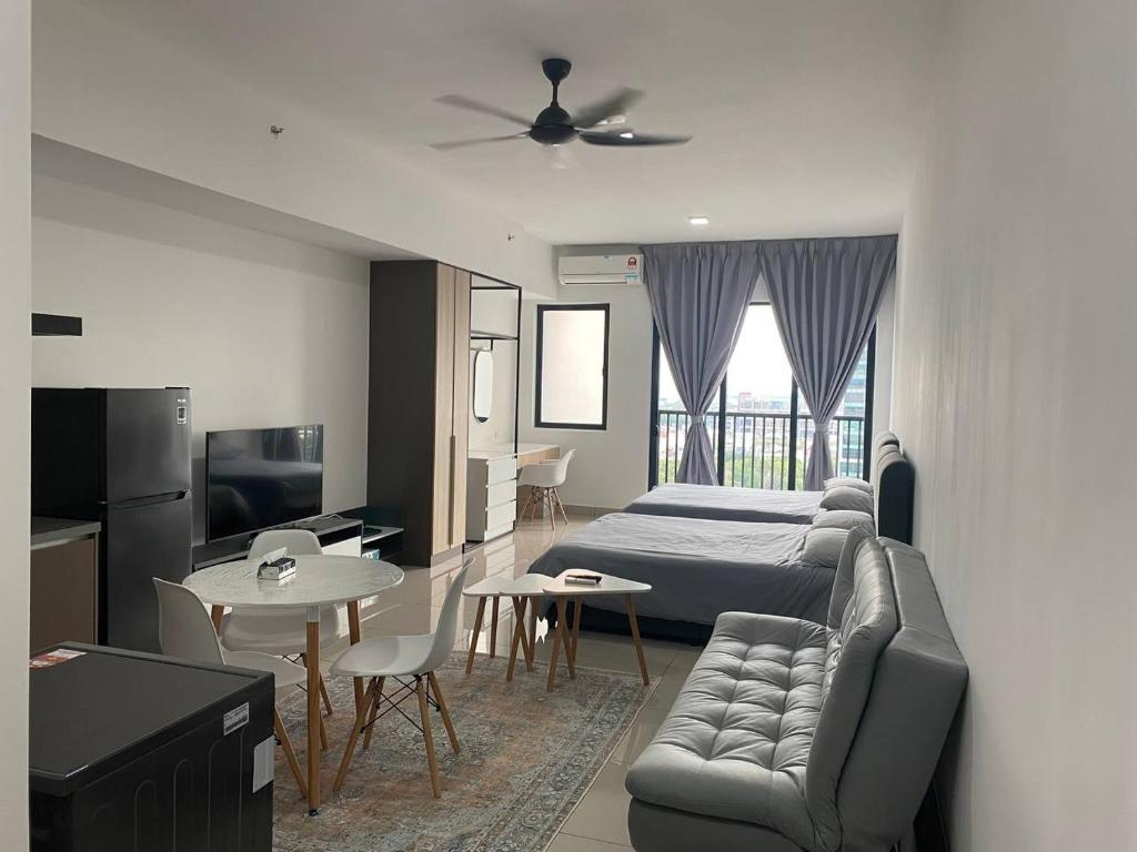 een slaapkamer met een bed, een bank en een tafel bij Alinea BlueView Suites in Shah Alam