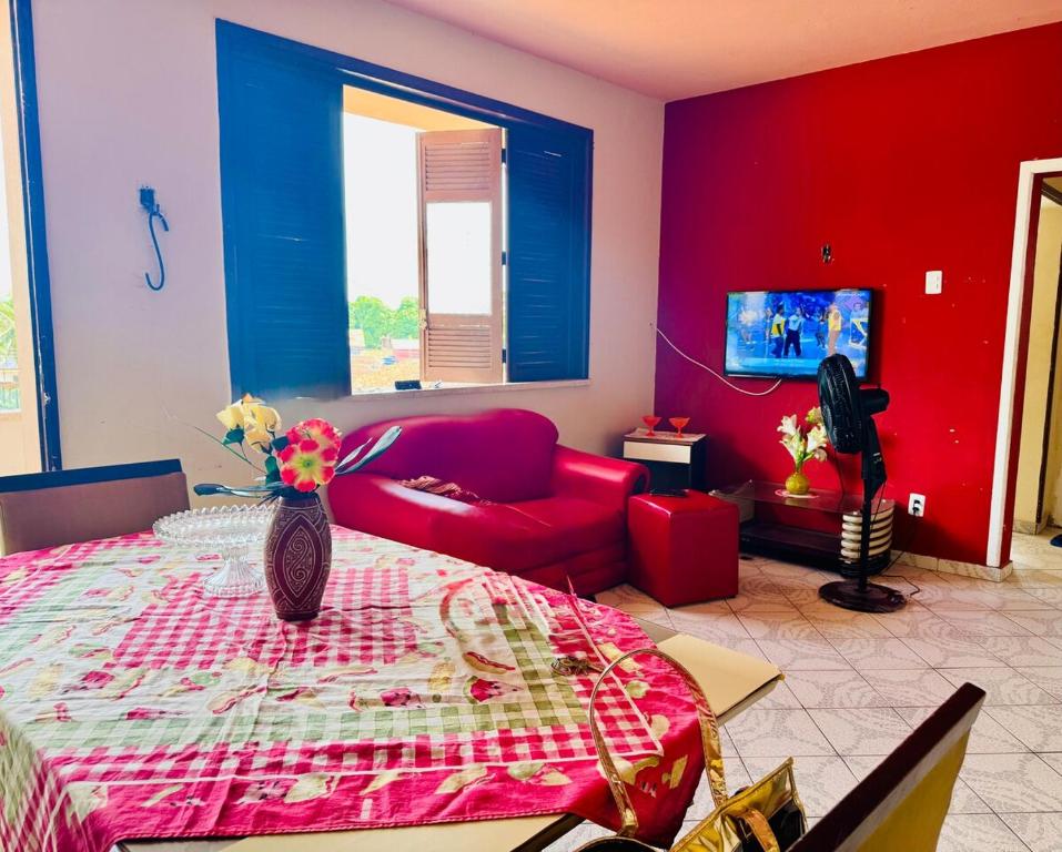 a living room with a red couch and a table at Apartamento praia do farol in Mosqueiro