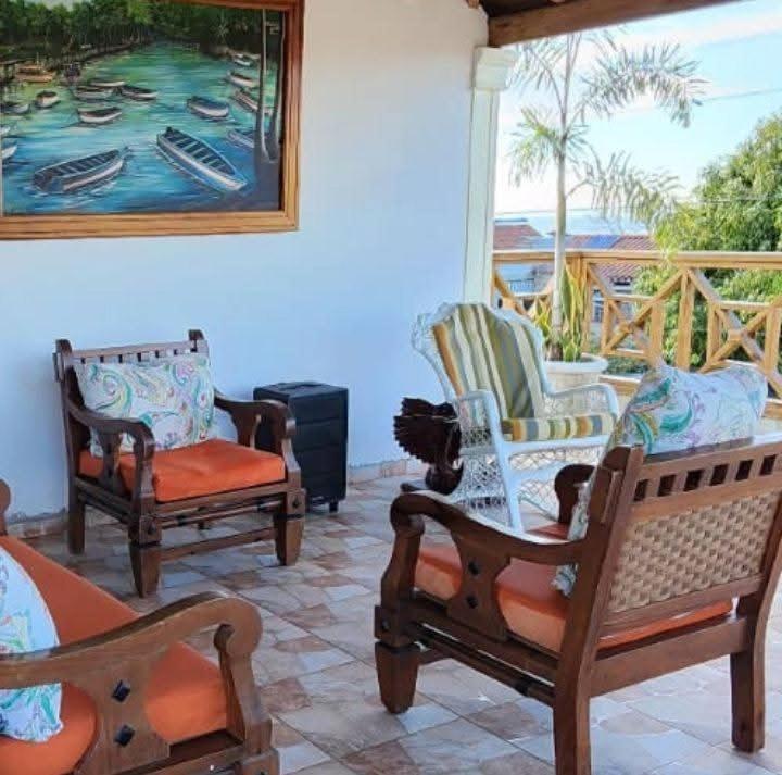 a porch with two chairs and a painting on the wall at Aparta hotel vista al mar in Río San Juan