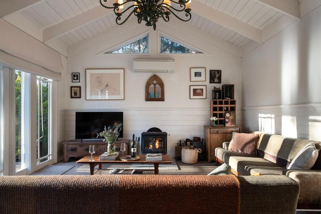 een woonkamer met een bank en een open haard bij Casa Adagio in Daylesford