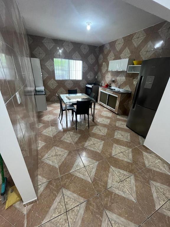 a kitchen with a table and chairs and a kitchen with a refrigerator at Casa 6 in Olinda