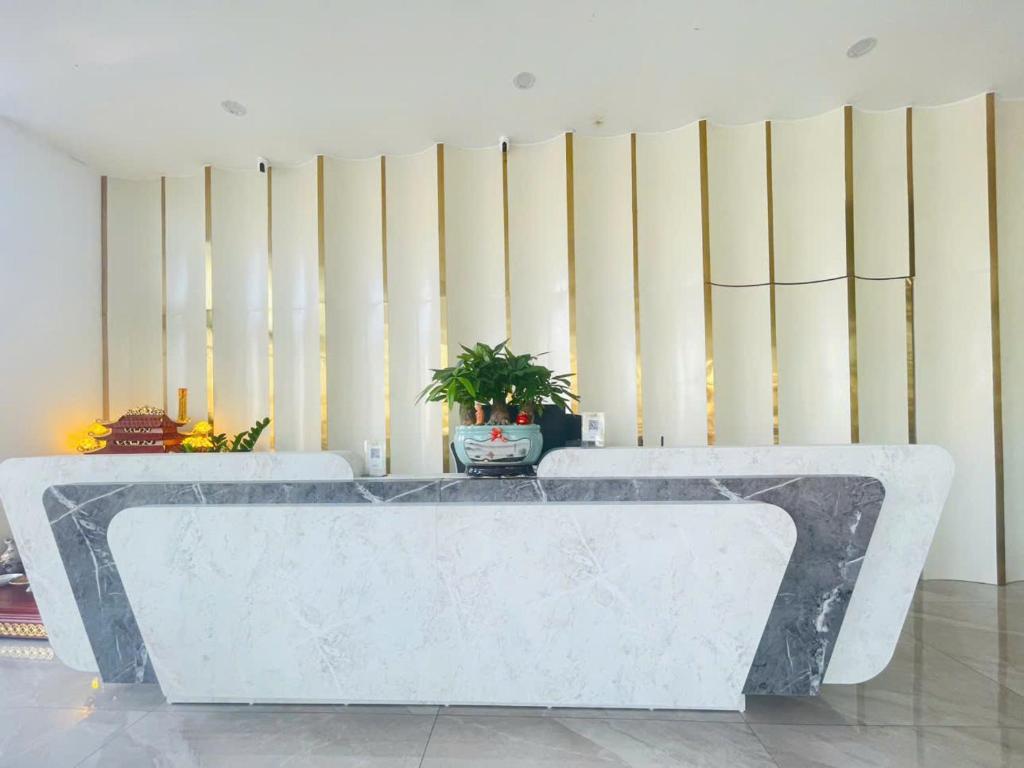 a room with two white tables in front of a wall at Tâm Khang Hotel in Móng Cái
