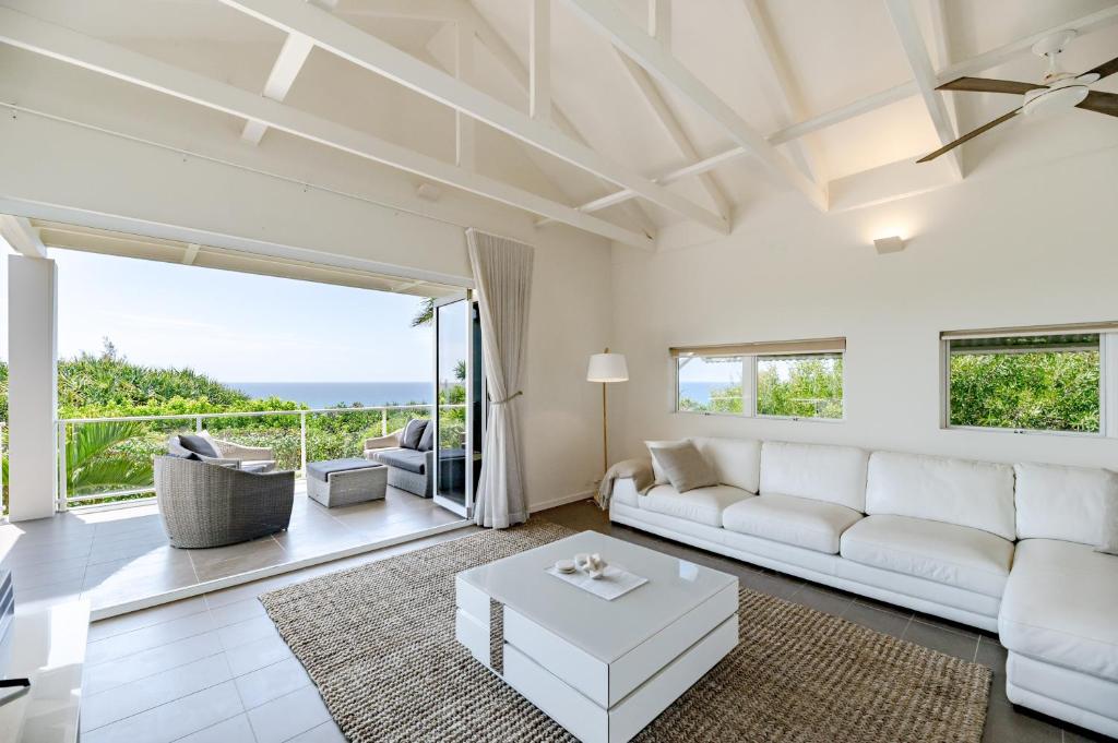 a living room with white furniture and a view of the ocean at Aqua North on Ross - Easy Walk to Beach & Village in Sunshine Beach
