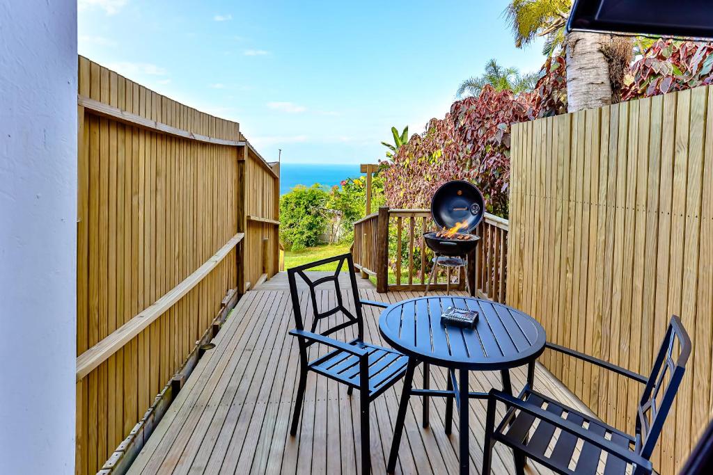 a patio with two chairs and a table and a grill at Rembrandt in Ballito