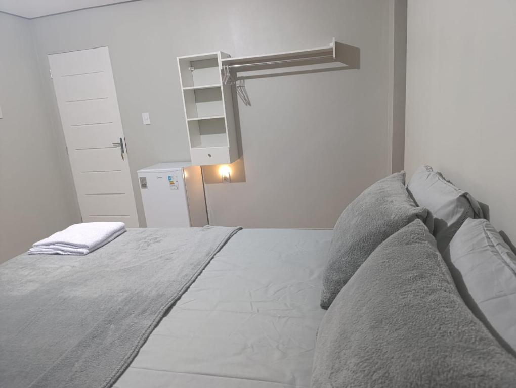 Un dormitorio blanco con una cama grande con almohadas. en Pousada Luz do Norte - Centro de Macapá, en Macapá
