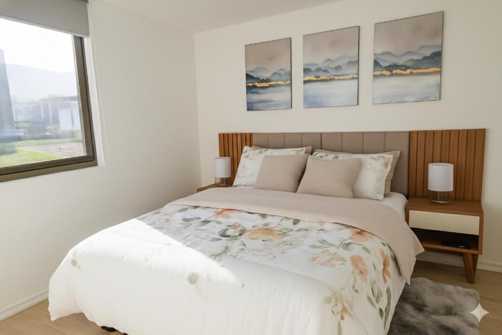 a bedroom with a white bed with three paintings on the wall at Papudo, Tus vacaciones soñadas!!! in Papudo