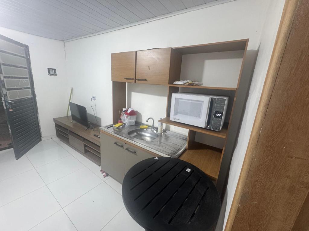 a small kitchen with a sink and a microwave at kitnet in Colombo