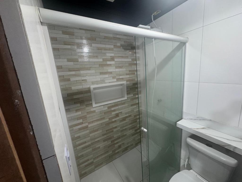 a bathroom with a glass shower with a toilet at kitnet in Colombo