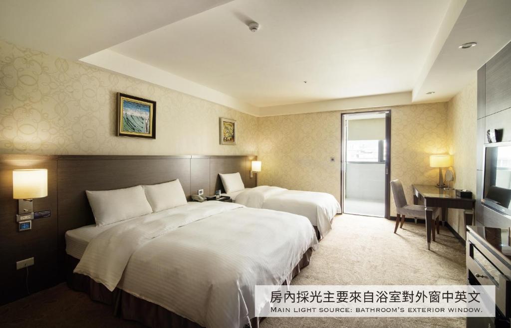 a hotel room with two beds and a desk and a television at Arsma Hotel in Hualien City