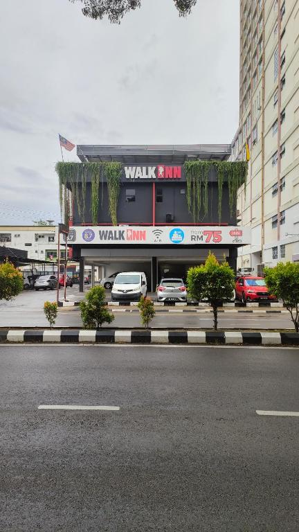 a building with cars parked in a parking lot at Walk Inn in Miri