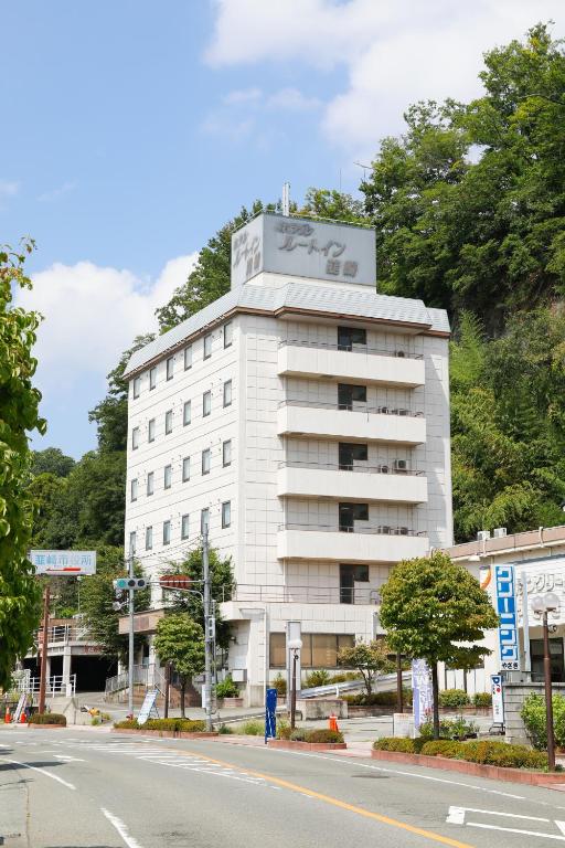 a white building on the side of a street at ホテルララプラス in Nirasaki