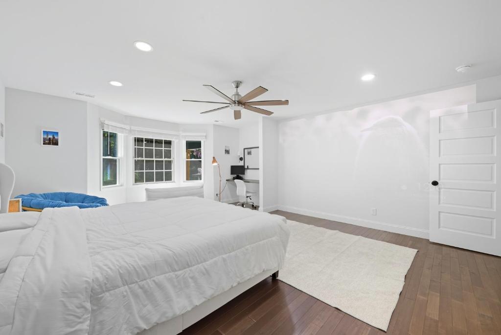 a white bedroom with a bed and a ceiling fan at Bedrooms with Private Bath - 12min from Uptown in Charlotte