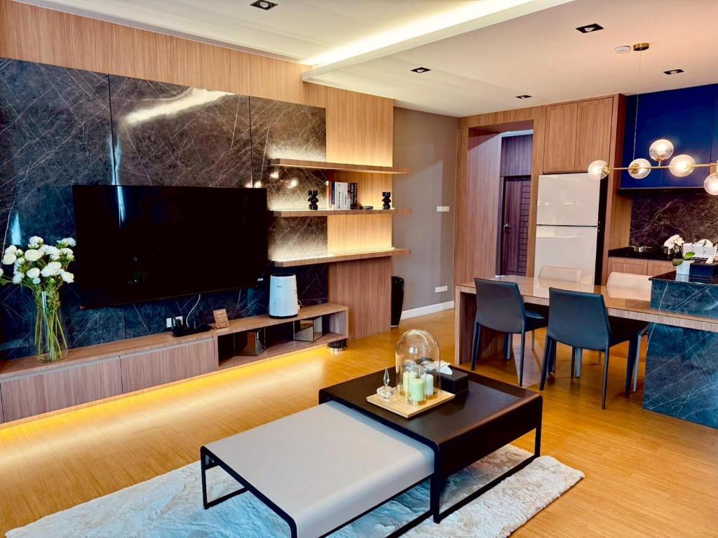 a living room with a television and a table at The Prestige Living Bangkok at Sathorn-Chan in Bangkok