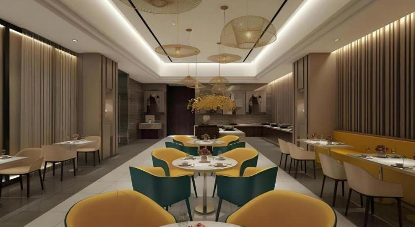 a restaurant with yellow and green chairs and tables at Jinjiang Inn Select Xixian New Distict Century Avenue in Xianyang