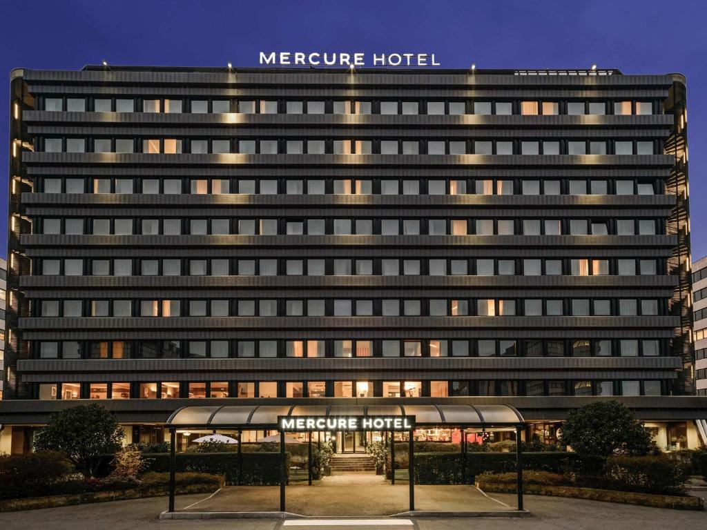 a large building with a sign on top of it at Mercure Milano Agrate Brianza in Agrate Brianza