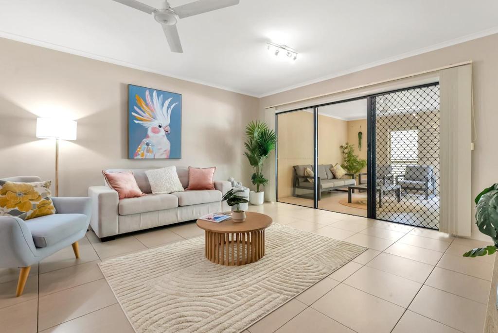 a living room with a couch and a table at Azure at The Edge, Steps to the Esplanade in Cairns North