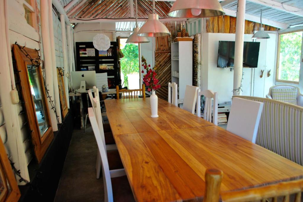 una sala da pranzo con un lungo tavolo in legno e sedie di Pacheco Farmhouse - Intag Valley a Peñaherrera