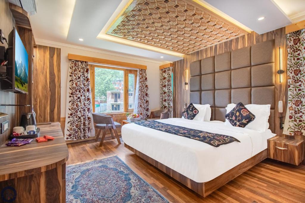 a hotel room with a large bed and a window at Bombay Residency in Pahalgām