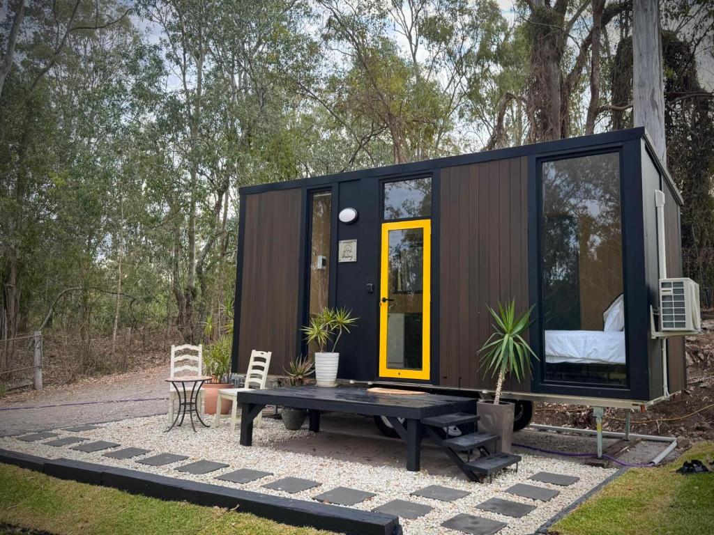 a tiny house on a patio with a table at Tranquility Ranch by Tiny Away in Wolfdene