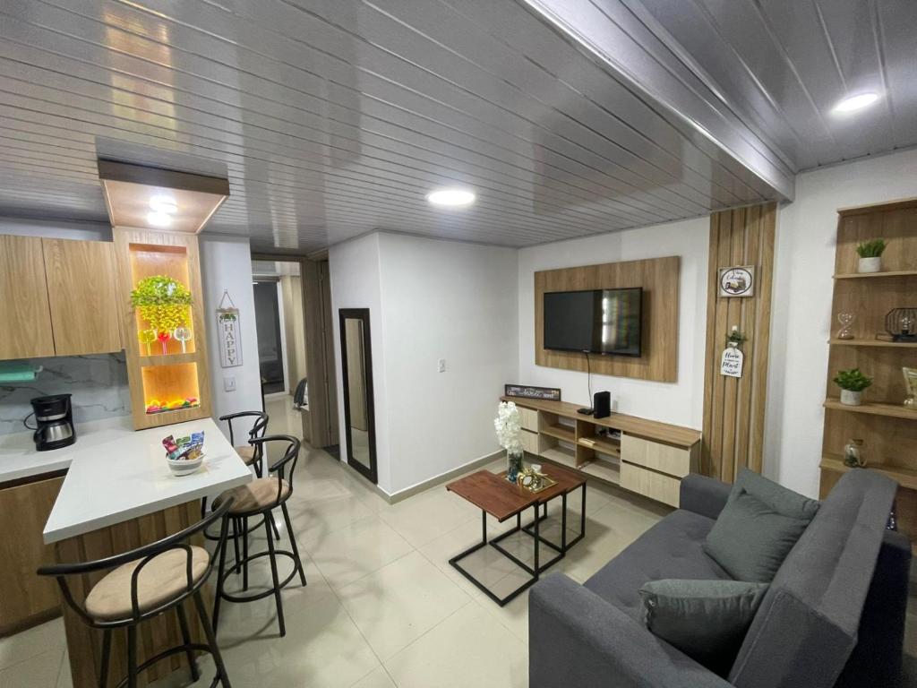 een woonkamer met een blauwe bank en een keuken bij Comfortable Mini apartment cerca de Chipichape in Estación El Salto