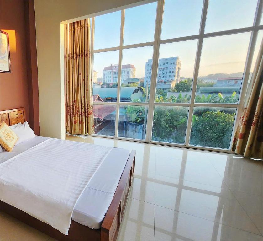 a bedroom with a bed and a large window at Roxbury house in Bản Múa