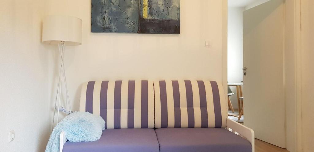 un salon avec un canapé violet et une lampe dans l'établissement Löhner Glück Perfekte Kombination von Geschäftsreise und Familie, à Löhne