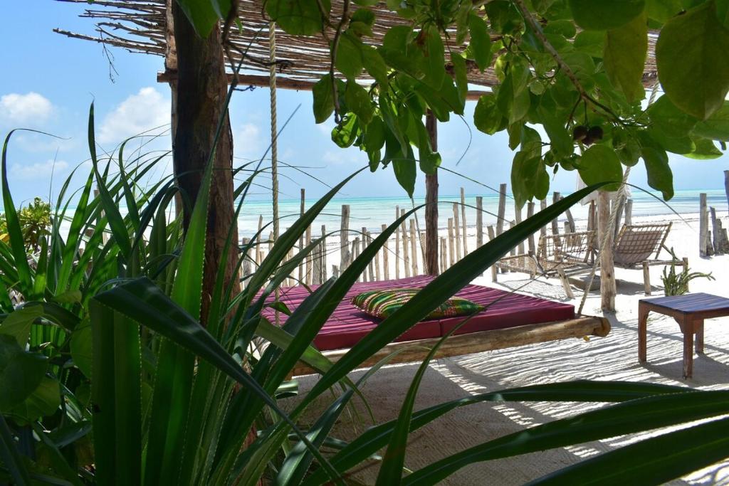 a bed on the beach with the ocean in the background at Hiliki private house in Umbuji